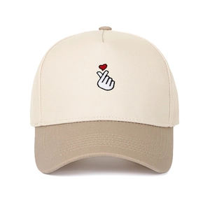 Close-up of the heart gesture embroidery on this two-tone beige and khaki baseball cap