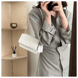 White woven PU leather shoulder bag shown on model in a stylish indoor mirror selfie
