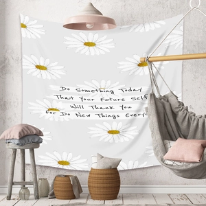 Detailed view of bohemian floral tapestry with white daisies and inspirational text