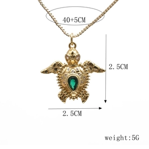 Detail shot of golden sea turtle pendant with green zircon inlay and size measurements
