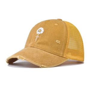 Detail of yellow washed denim trucker hat with daisy embroidery and distressed visor