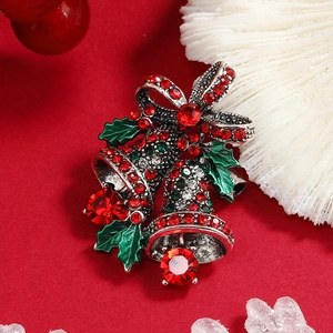 Festive Christmas bell brooch with red and green rhinestones on a holiday background