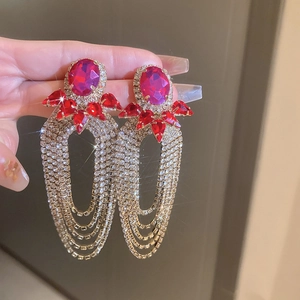 Detail of rose pink oval zircon earrings with red accents and rhinestone fringe tassels