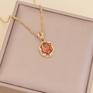 Close-up of golden sunflower pendant with colorful gems and diamonds in a jewelry box