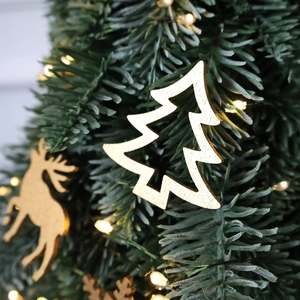 Golden wooden reindeer and tree ornaments decorating a pine branch for Christmas DIY