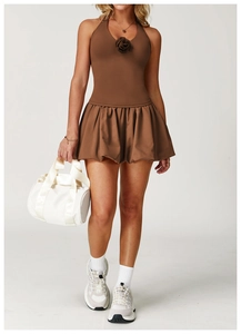 Detail view of the brown halter neck dress featuring a 3D rose accent and bubble hem design