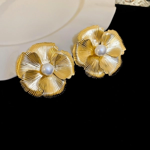 Details von Vintage-Goldohrringen in Blumenform mit gebürsteten Blättern und Perle