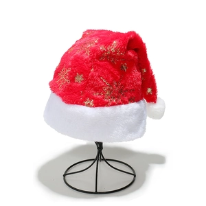 Detailed view of red velvet Christmas hat featuring metallic gold snowflake prints