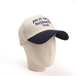 Close-up of embroidered text and contrast stitching on a two-tone baseball cap