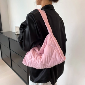 Detailed macro view of pink quilted nylon shoulder bag with soft puffer diamond pattern