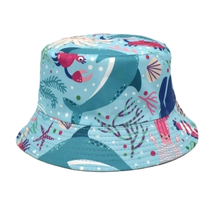 Dettaglio dei motivi marini con balene e granchi su un cappello a secchiello blu