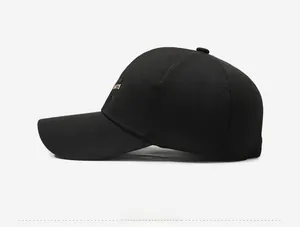 Detail of black cotton baseball cap featuring gold HATS embroidery on the side panel