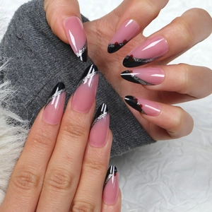 Pink and black French almond press-on nails with silver glitter lines on a model's hand