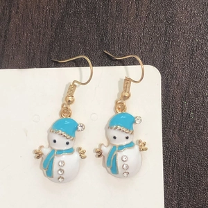 Detail of snowman drop earrings with blue enamel and rhinestones on white card