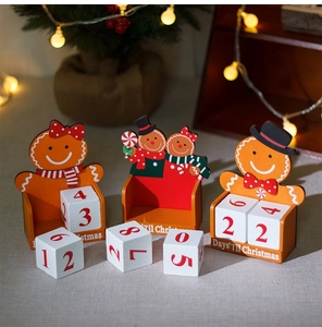 Detail of wooden gingerbread couple advent calendar with countdown cubes and festive lights