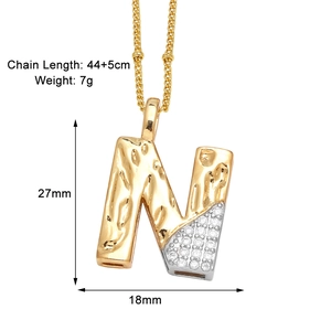 Vue détaillée du pendentif lettre N dorée avec incrustation de zircon blanc et texture