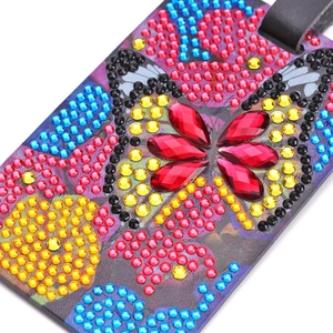 Macro detail of 5D DIY diamond painting butterfly luggage tag with colorful rhinestones