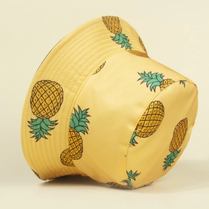Close-up of neat stitching on yellow canvas bucket hat with pineapple print patterns