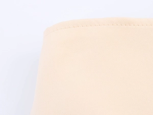 Detail shot of beige high-quality textile fabric with neat stitching and fine texture
