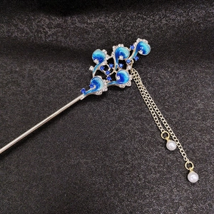Close-up of blue enamel flower petals and white pearl tassels on silver hair pin
