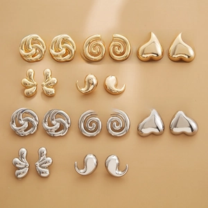 Detail view of various geometric stud earrings in polished gold and silver finishes