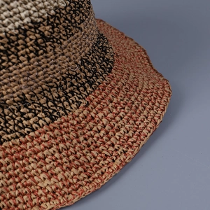 Detailed macro view of the three-color hand-woven fiber texture on a sun hat