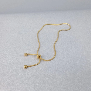 Dettaglio di un bracciale a catena serpente in oro 18 carati con perline e finitura lucida
