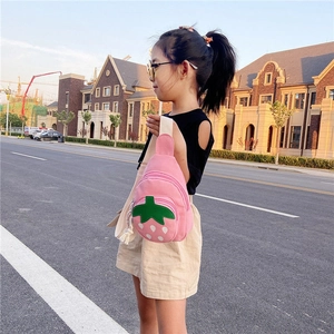 Pink strawberry shaped crossbody chest bag with adjustable strap worn by a young child