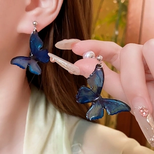 Elegant butterfly stud earrings with blue resin wings and white pearl backings