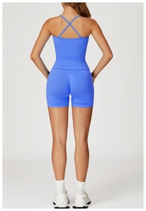 Detail of cross-back thin straps on a vibrant blue yoga top and high-waist shorts