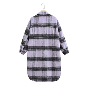 Detail of purple and grey plaid wool coat showing fabric texture and buttoned cuffs