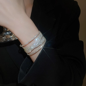 Close-up of sparkling multilayer rhinestone crossover bracelet with pearl accents on wrist