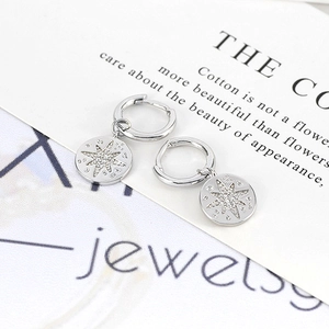 Macro view of silver starburst drop earrings with micro-set cubic zirconia detail