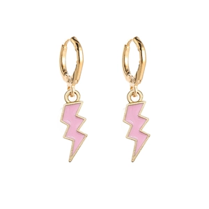 Detail view of gold earrings with pink lightning bolt pendants on a white background