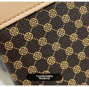 Detail of premium brown pebble leather featuring golden clover pattern and neat stitching