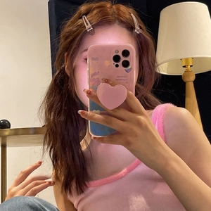 Pink heart-shaped phone grip on a smartphone case with a matte textured finish