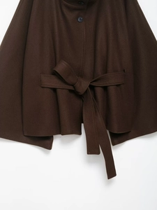 Detailed view of dark brown wool coat featuring fabric texture, matching belt and buttons