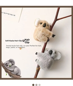 Detailed view of grey and brown plush koala hair clips attached to a tree branch