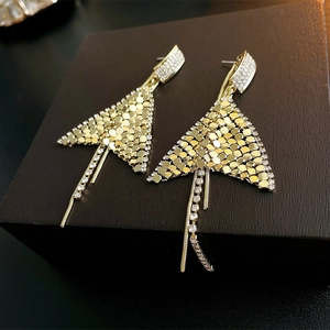 Macro shot of gold tassel earrings with rhinestone mesh and long chain details