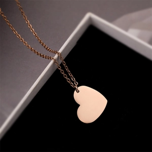 Macro view of polished rose gold heart pendant necklace on black velvet display