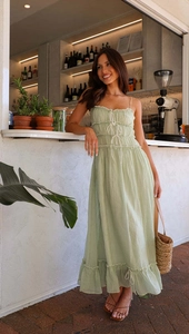 Détail d'une robe mi-longue vert sauge avec cordon de serrage et ourlet à volants