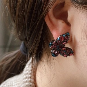 Pendientes de mariposa bañados en plata con circonitas rosas y metal negro en contraste