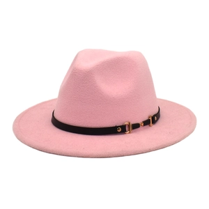 Detailed texture of pink wool fedora hat with black leather belt and gold buckle