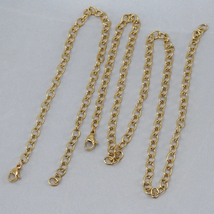 Golden stainless steel O-link chain necklaces with lobster clasps on gray textured fabric