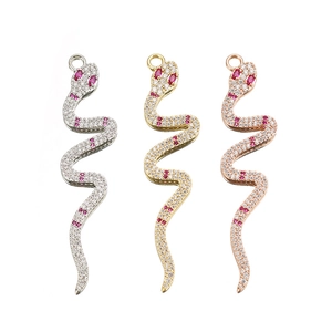 Detailed view of snake charms in gold, silver, and rose gold with micro-pave crystals