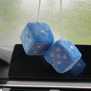 Detail view of blue plush dice car pendant with pink heart embroidery and hanging cord