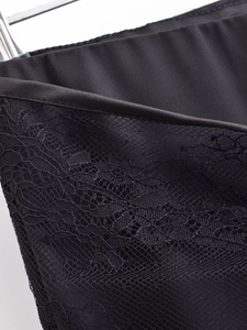 Detailed view of black satin fabric texture and elegant lace trim on the trousers