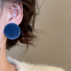 Close-up of deep blue velvet round stud earring on model with elegant side profile view