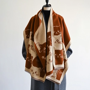 Detail of soft reversible cashmere-like shawl with cute cat patterns and fringed edges