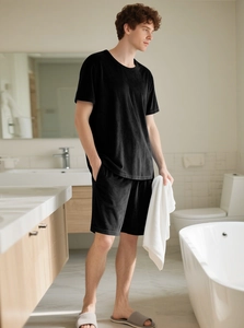 Detail of men's black velvet lounge set showing fabric texture in a modern bathroom setting